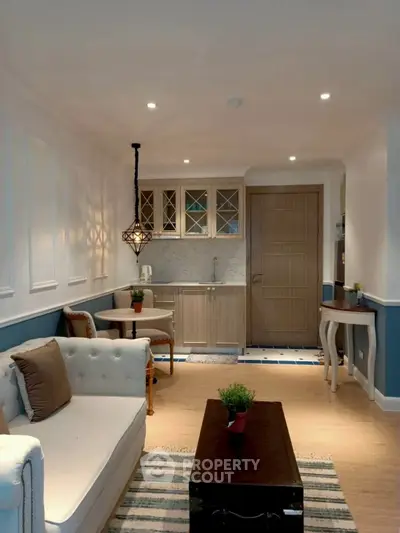 Charming living room with cozy seating and stylish kitchenette in modern apartment.