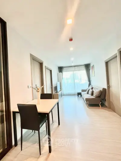 Modern living room with sleek furniture and city view through large windows.