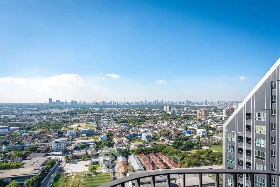 Stunning cityscape view from a high-rise balcony with clear blue skies.