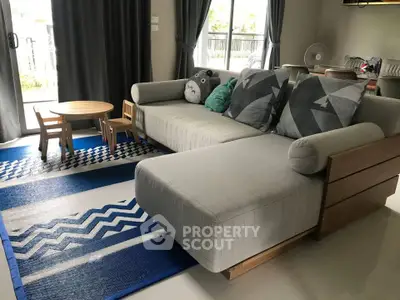 Spacious living room with modern sofa and playful decor, perfect for family gatherings.