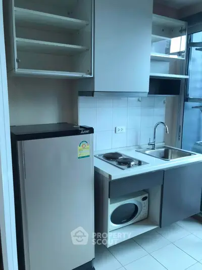 Compact kitchen with modern appliances and sleek cabinetry in urban apartment