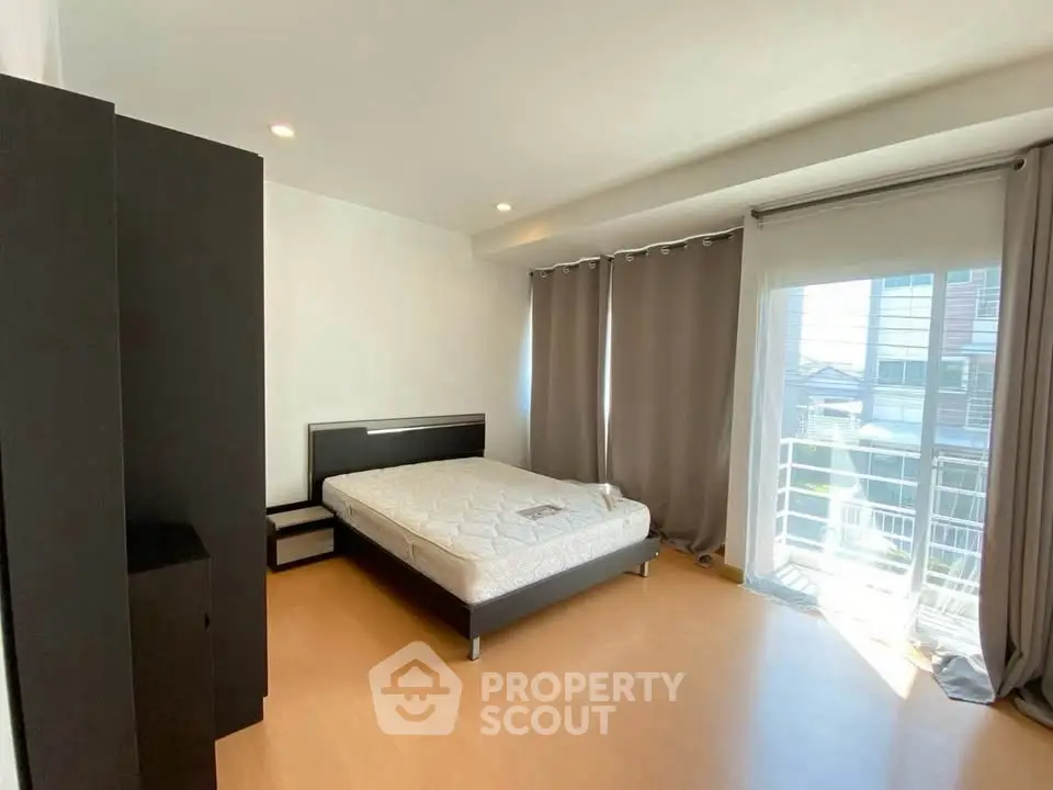 Spacious bedroom with natural light and modern furnishings in a stylish apartment.