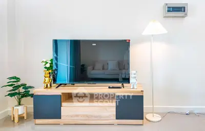 Modern living room with stylish TV stand, sleek flat-screen TV, and elegant floor lamp.