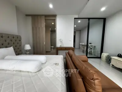 Spacious modern bedroom with elegant decor and cozy seating area