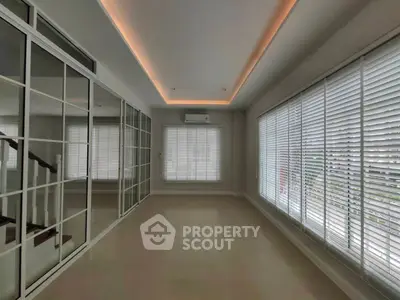 Spacious room with large windows and modern blinds, perfect for natural light and airy ambiance.