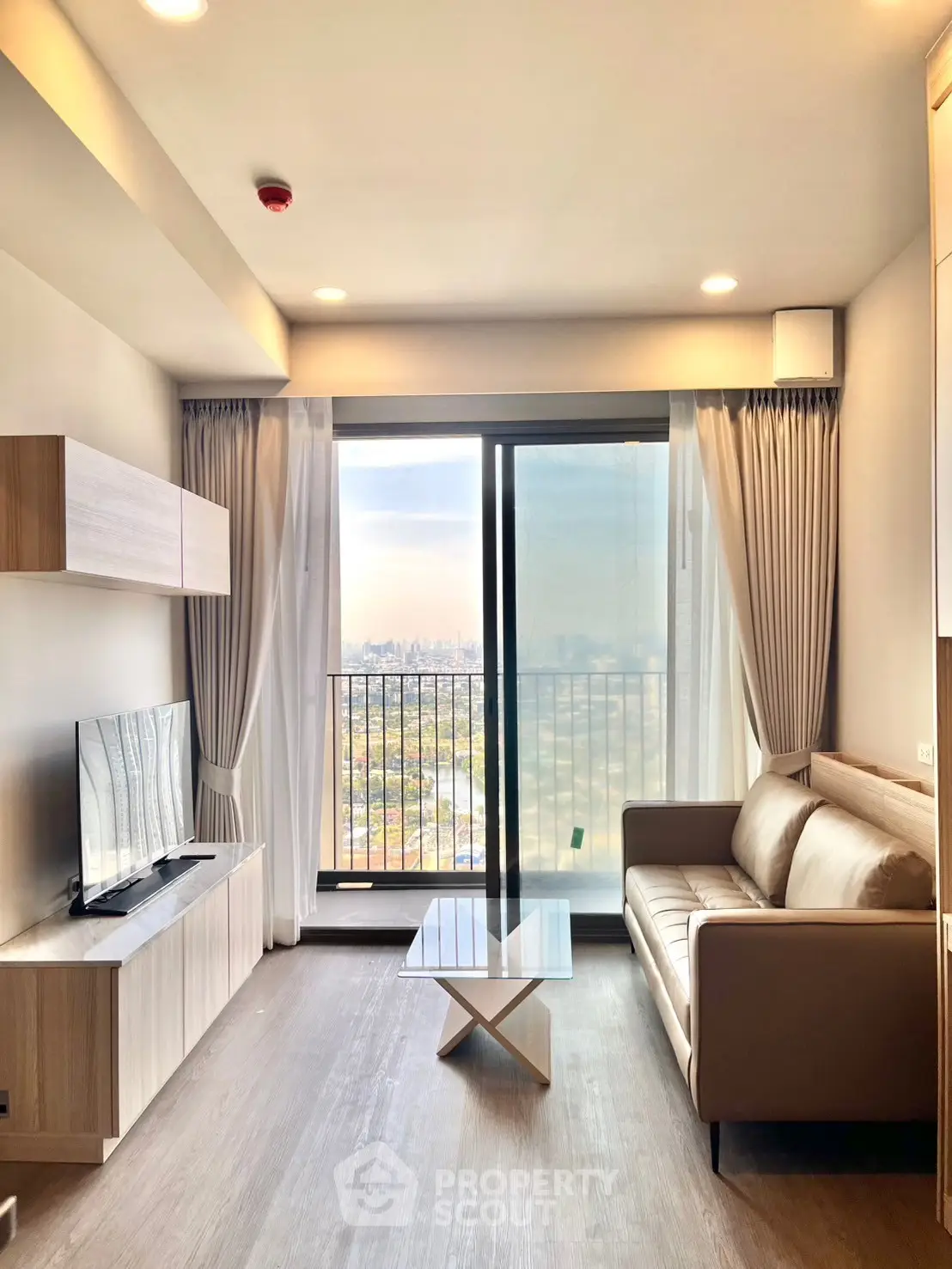 Modern living room with balcony view, sleek furniture, and natural light.