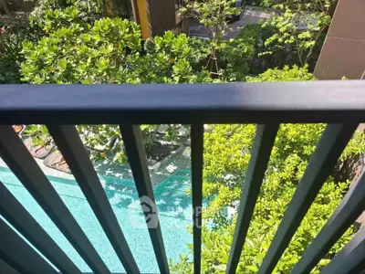 Stunning view from balcony overlooking lush garden and sparkling pool