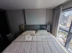Modern bedroom with large windows offering stunning city views