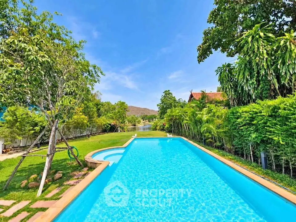 Luxurious outdoor pool with lush greenery and scenic views, perfect for relaxation and leisure.