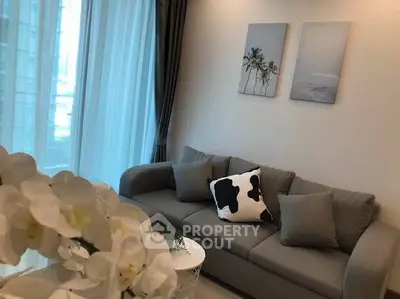 Modern living room with stylish decor and large windows in a high-rise apartment.