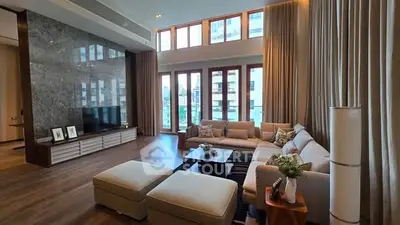Luxurious living room with high ceilings and large windows offering natural light.