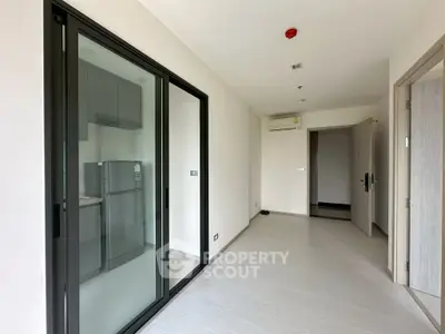 Modern apartment interior with sliding glass doors and sleek kitchen design