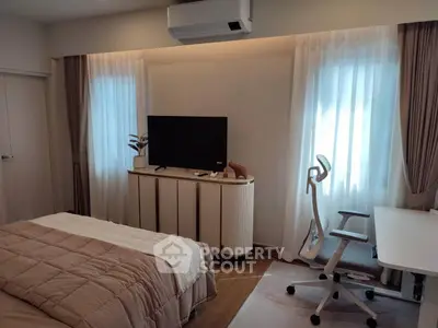 Modern bedroom with stylish decor, featuring a cozy bed, sleek TV stand, and ergonomic office chair.