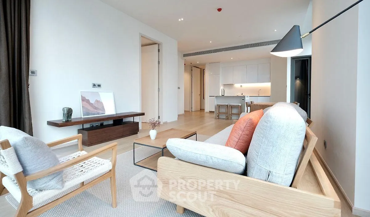 Modern open-plan living room with stylish furniture and kitchen area