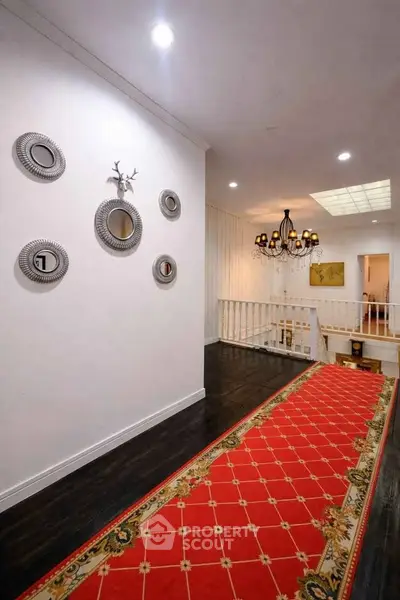 Elegant hallway with red carpet and decorative wall mirrors in a stylish home