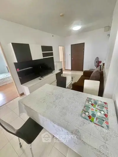 Cozy living room with modern furniture and dining area in open layout apartment.