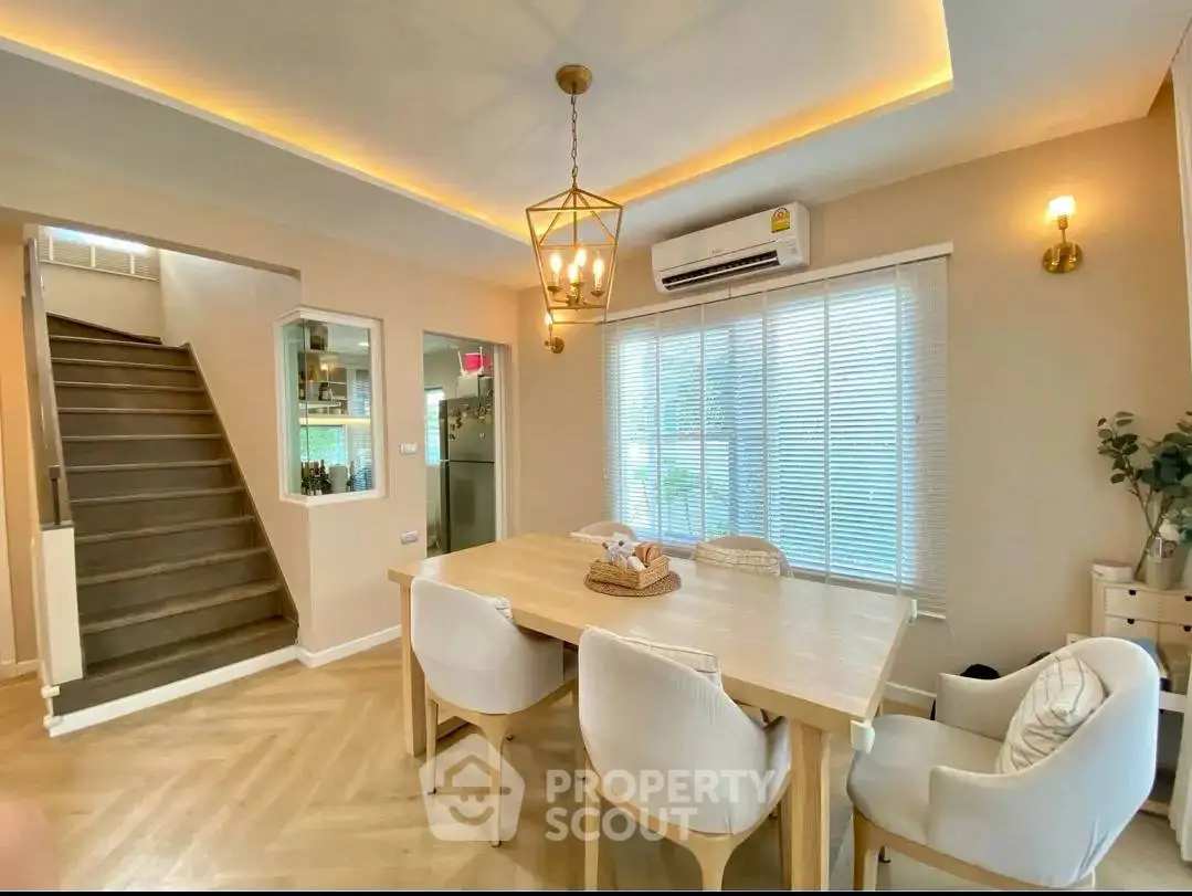 Elegant dining area with modern lighting and natural light, perfect for family gatherings.