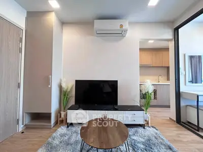 Modern living room with sleek TV setup and cozy kitchen view