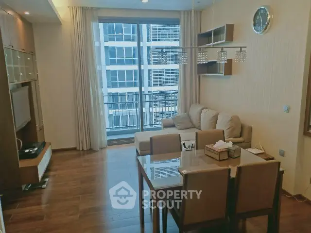 Spacious living room with modern decor and large windows offering city views.