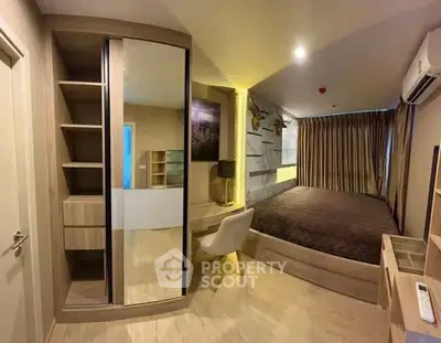 Modern bedroom with stylish decor, mirrored wardrobe, and cozy lighting