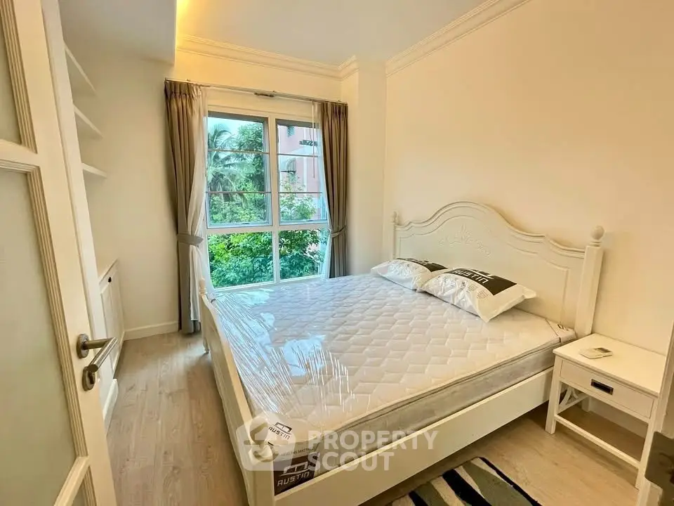 Cozy bedroom with large window and elegant white furniture