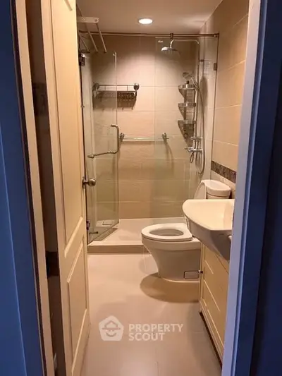Modern bathroom with glass shower and sleek fixtures in a cozy apartment.