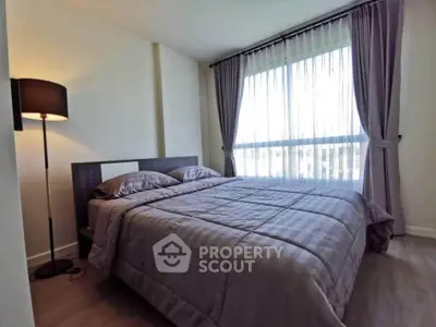 Cozy bedroom with large window and elegant curtains, perfect for relaxation and comfort.