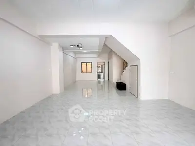 Spacious open-plan living area with modern tiled flooring and neutral walls, perfect for customization.