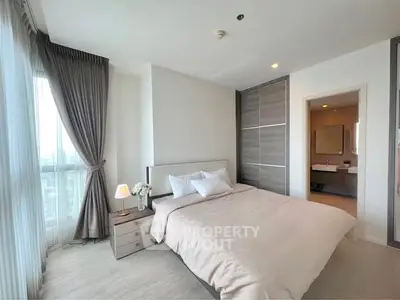 Modern bedroom with elegant decor and ensuite bathroom in luxury apartment.