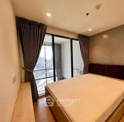 Spacious bedroom with city view and large windows in modern apartment