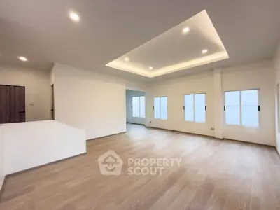 Spacious modern living room with recessed lighting and wooden flooring
