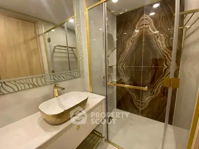 Luxurious bathroom with elegant marble shower and gold accents