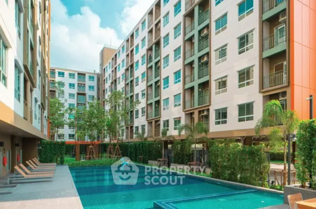 Modern apartment complex with inviting outdoor pool and lush greenery.