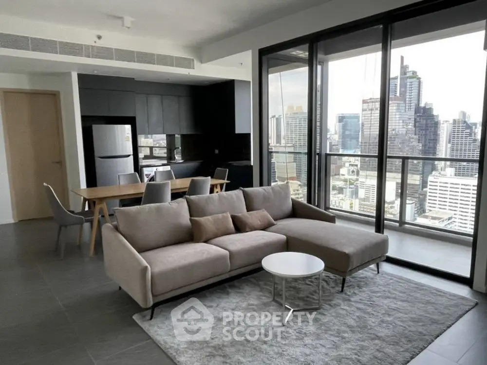 Modern living room with city view, open kitchen, and stylish furniture in high-rise apartment.