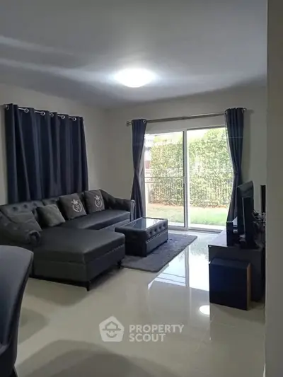 Spacious living room with modern decor and garden view, perfect for relaxation and entertainment.