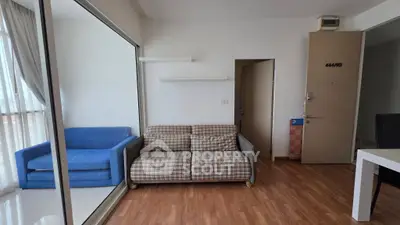 Modern living room with stylish sofas and wooden flooring, featuring large windows for natural light.
