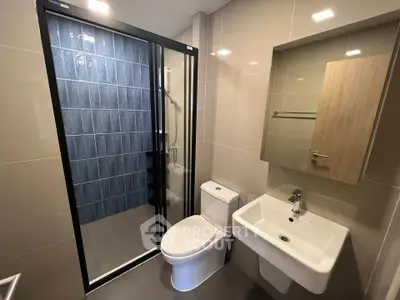 Modern bathroom with sleek design featuring glass shower and contemporary fixtures.
