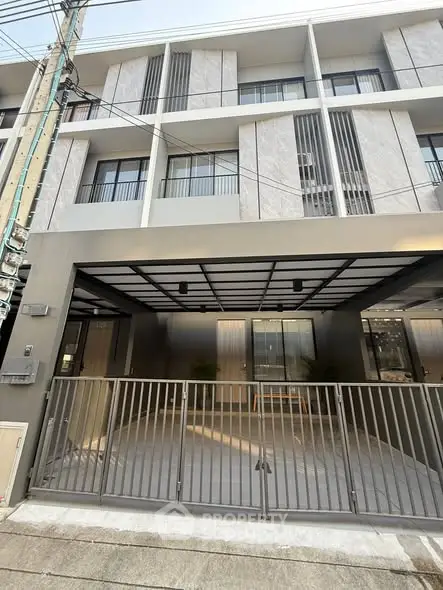 Modern townhouse exterior with sleek design and gated entrance