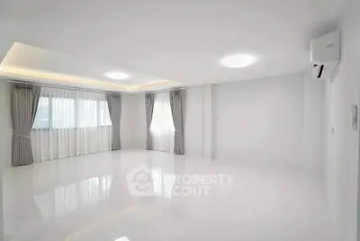 Spacious empty living room with large windows and modern lighting