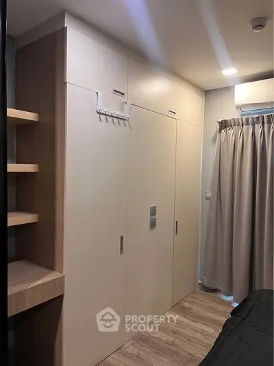 Modern bedroom with built-in wardrobe and air conditioning unit