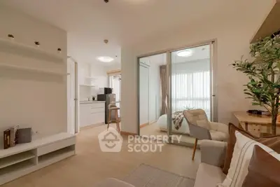 Modern apartment interior with open living room and kitchen, featuring cozy decor and natural light.