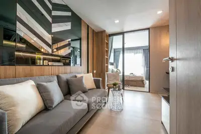 Modern living room with stylish decor and view into a cozy bedroom, featuring elegant furnishings and natural light.