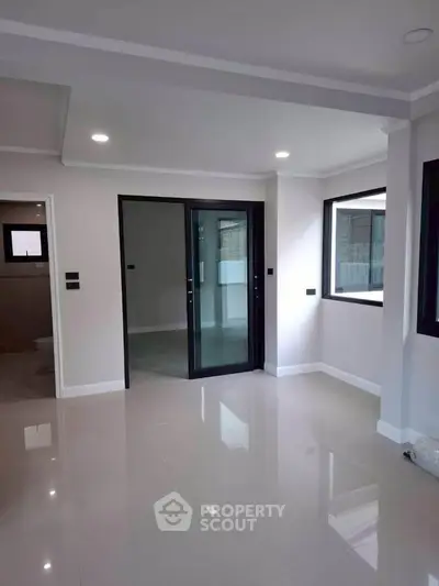 Modern interior with sleek glass doors and glossy tile flooring, perfect for contemporary living.