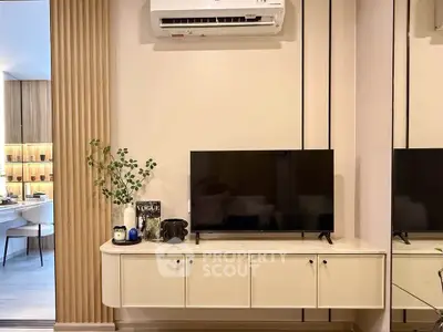 Modern living room with sleek TV unit and air conditioning, adjacent to stylish dining area.