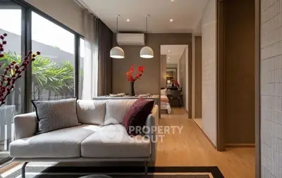 Modern living room with elegant decor and natural light, featuring a cozy sofa and stylish pendant lights.