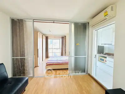 Modern apartment with sliding glass doors, wooden flooring, and bright natural light.