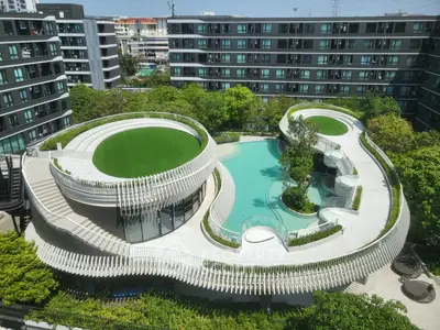Stunning modern apartment complex with unique rooftop garden and pool design, offering luxurious urban living.