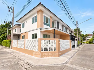 Modern two-story corner house with stylish facade and privacy fence in suburban neighborhood.