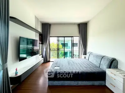 Spacious modern bedroom with large window and sleek furnishings in a contemporary home.