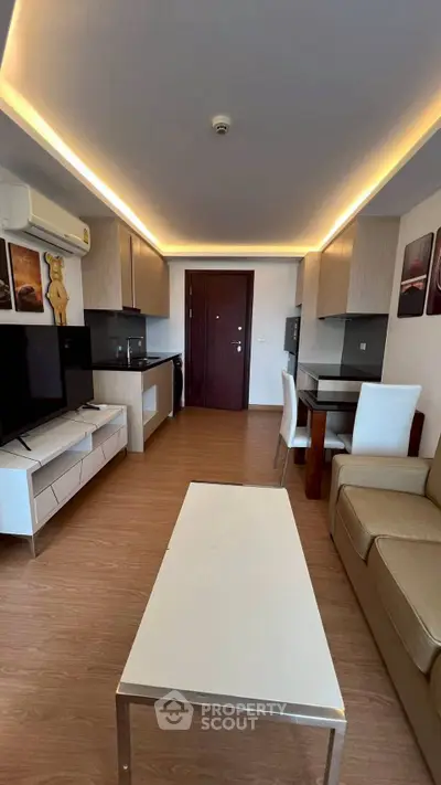 Modern living room with sleek design, featuring a cozy sofa, flat-screen TV, and stylish lighting.